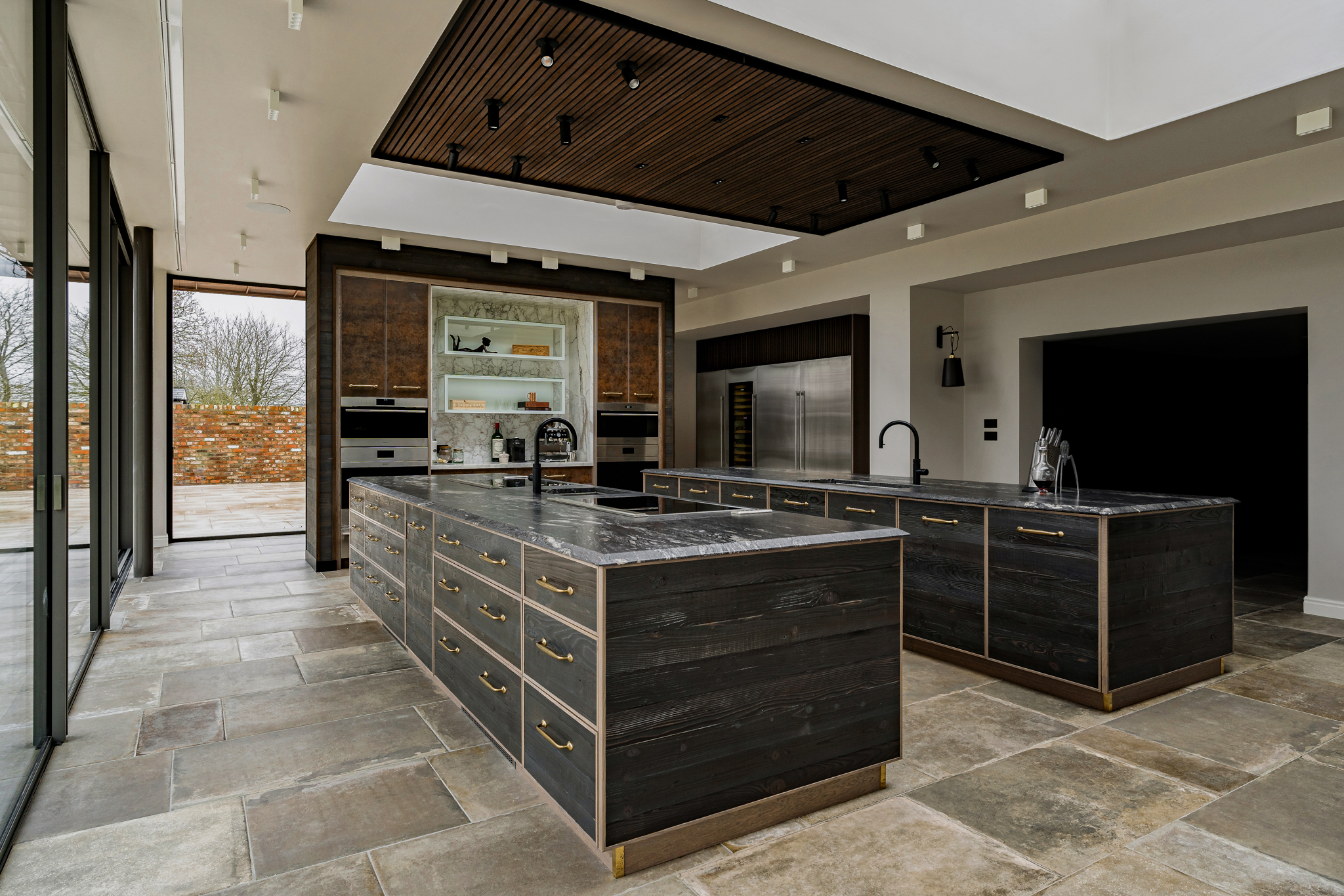 A wide angle image of a bespoke rustic english kitchen with two islands